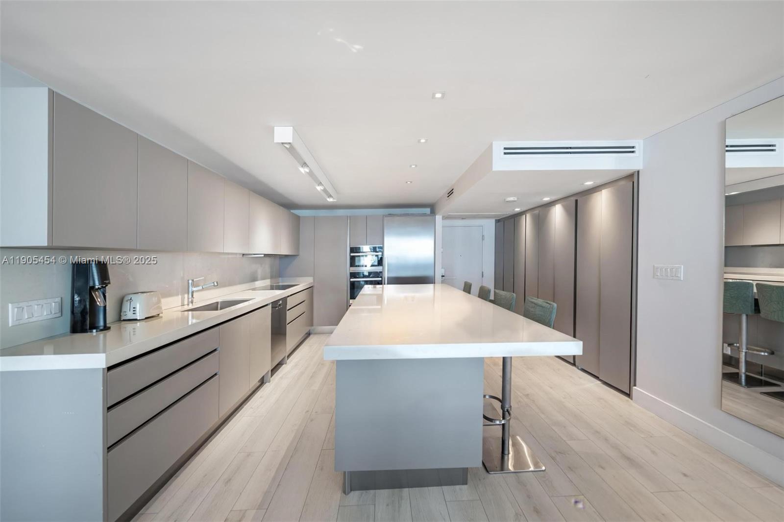 2301 Collins Avenue, Unit 1414/1415 Miami Beach, FL 33139 - Photo 17 of 40 a large kitchen with a table chairs sink and cabinets