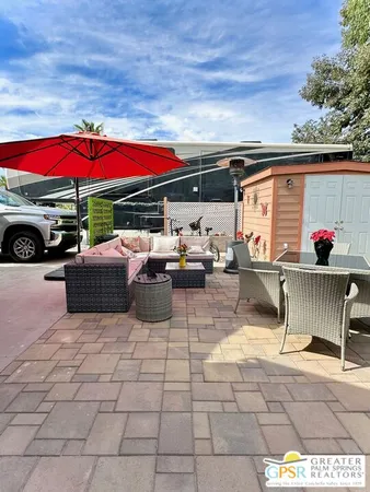 a view of a patio with table and chairs under an umbrella