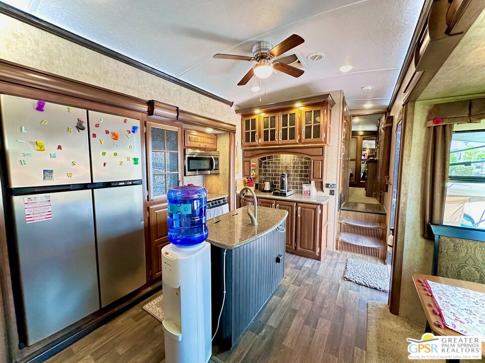69801 Ramon Road, Unit 266 Cathedral City, CA 92234 - Photo 9 of 23 a kitchen with stainless steel appliances granite countertop a refrigerator and a stove