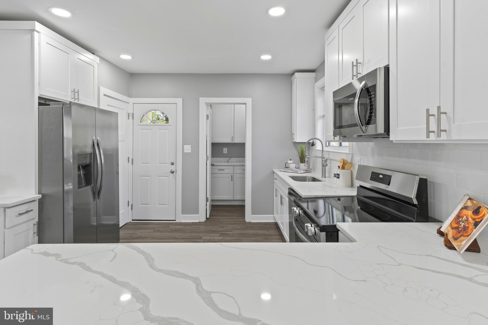 5728 Clover Road Baltimore, MD 21215 - Photo 11 of 40 a kitchen with stainless steel appliances a refrigerator and a stove top oven