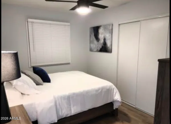 a bedroom with a bed and a painting on the wall