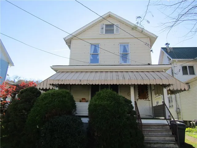 a front view of a house with plants