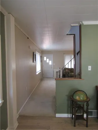 a view of a hallway to a livingroom with furniture and windows