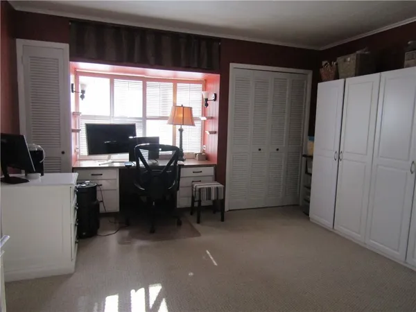 a view of a workspace with furniture and a window