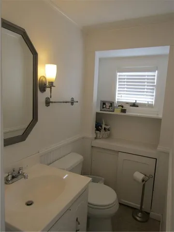 a bathroom with a sink a toilet and mirror