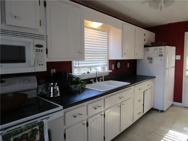 a kitchen with stainless steel appliances white cabinets a sink and a stove