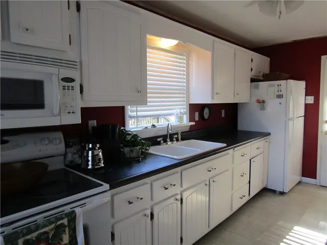 a kitchen with stainless steel appliances white cabinets a sink and a stove