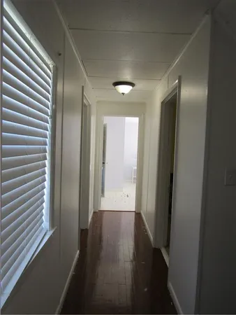 a view of a hallway with wooden floor and closet
