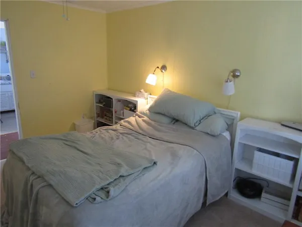 a bedroom with a bed and a lamp on the dresser