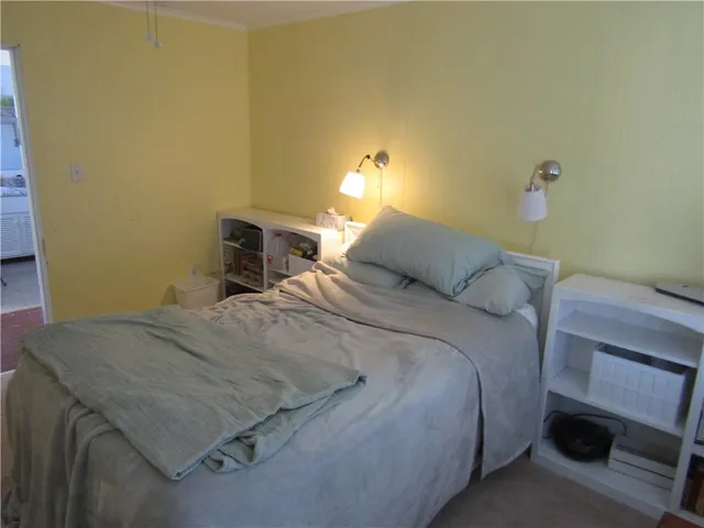 a bedroom with a bed and a lamp on the dresser