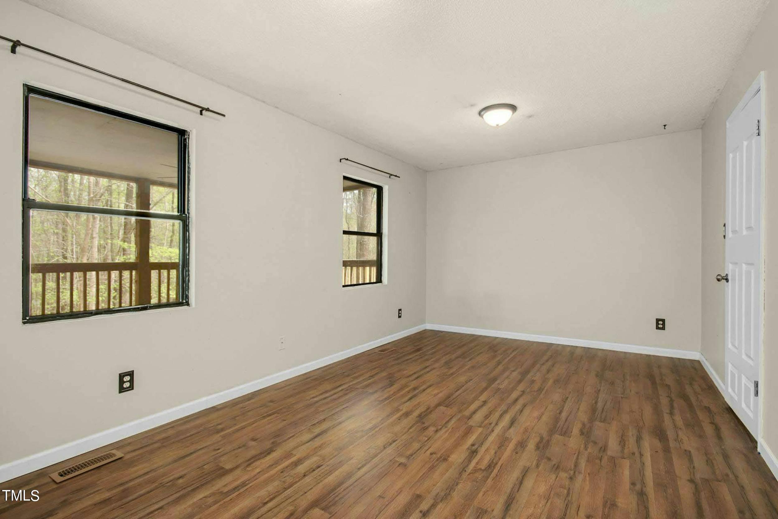 2609 Carpenter Pond Road Raleigh, NC 27613 - Photo 13 of 33 an empty room with wooden floor and windows
