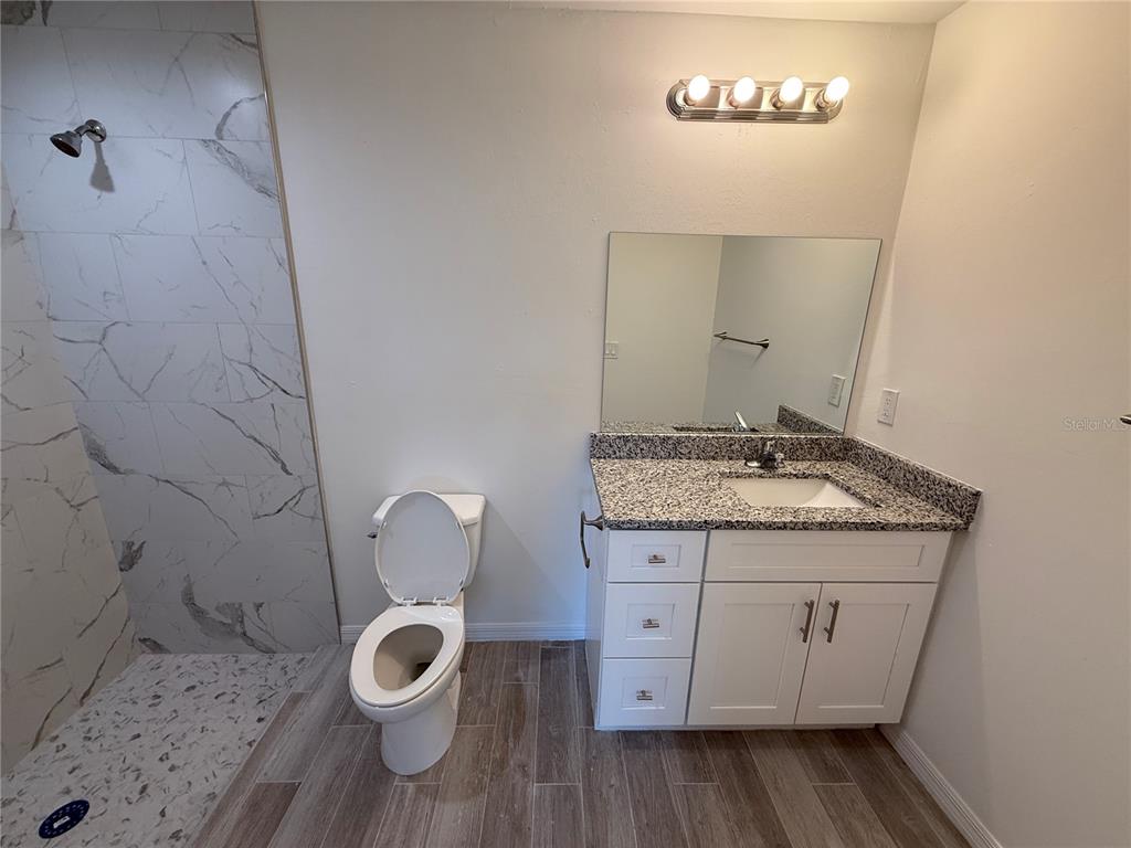5290 Arley Road North Port, FL 34288 - Photo 13 of 26 a bathroom with a granite countertop toilet a sink and a mirror