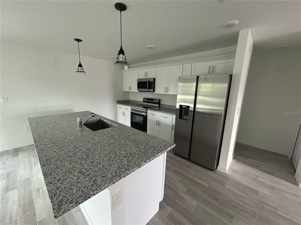 5290 Arley Road North Port, FL 34288 - Photo 2 of 26 a kitchen with stainless steel appliances granite countertop a stove a refrigerator and a sink