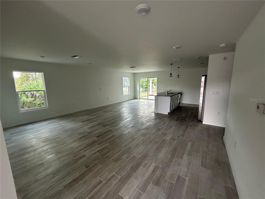5290 Arley Road North Port, FL 34288 - Photo 3 of 26 an empty room with wooden floor and windows