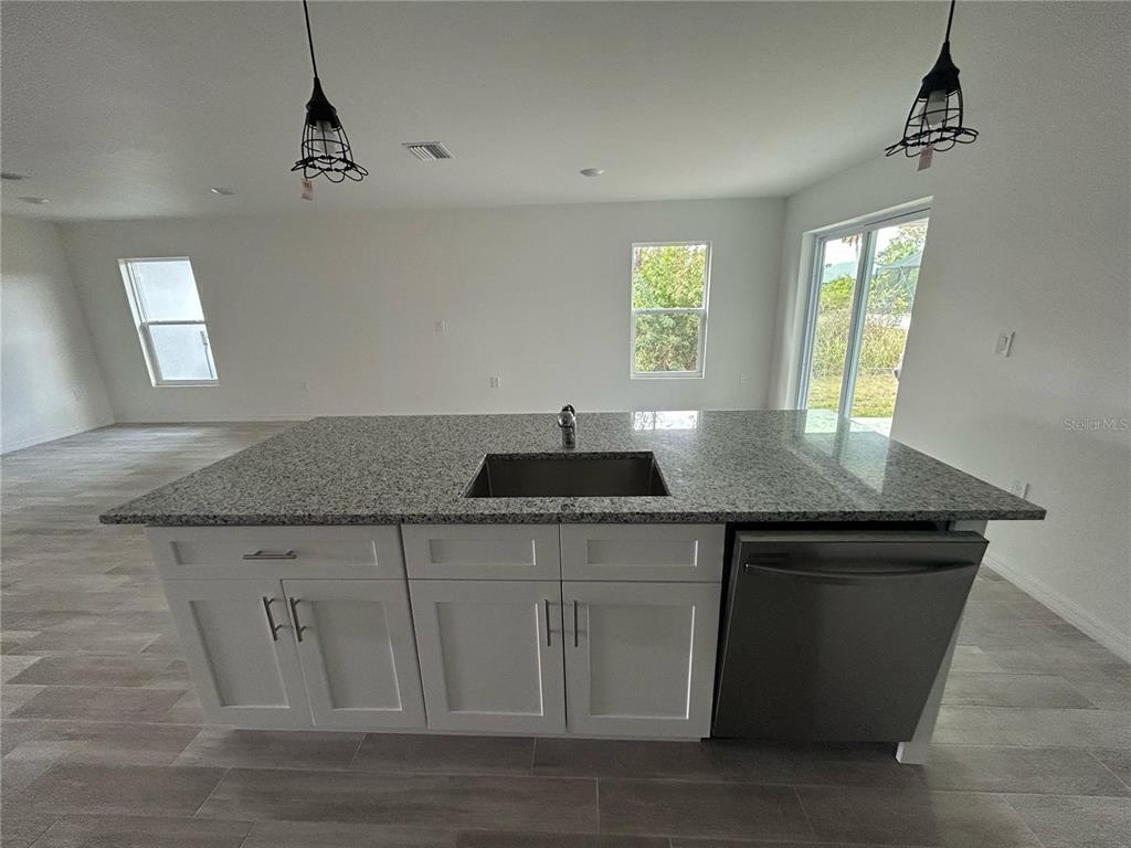 5290 Arley Road North Port, FL 34288 - Photo 4 of 26 a kitchen with granite countertop a sink cabinets and wooden floor