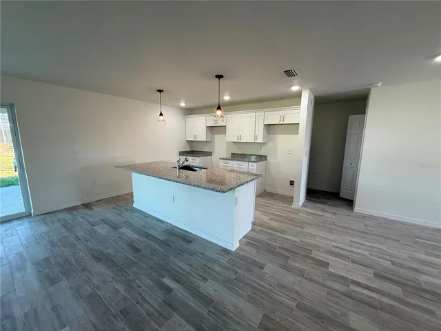 a kitchen with stainless steel appliances granite countertop a sink a stove a refrigerator and cabinets