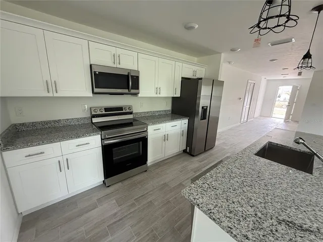 a bathroom with a granite countertop toilet sink and mirror