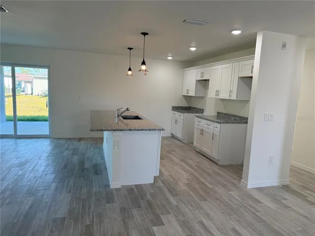 a kitchen with a sink and wooden floor