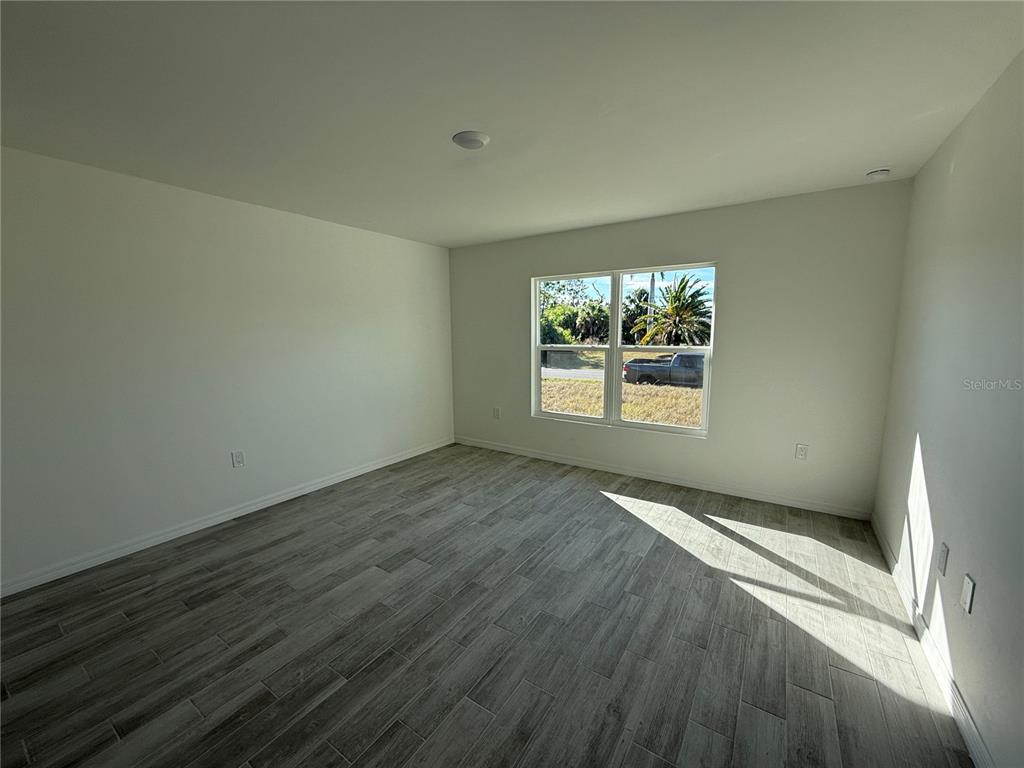 5290 Arley Road North Port, FL 34288 - Photo 9 of 26 an empty room with wooden floor and windows
