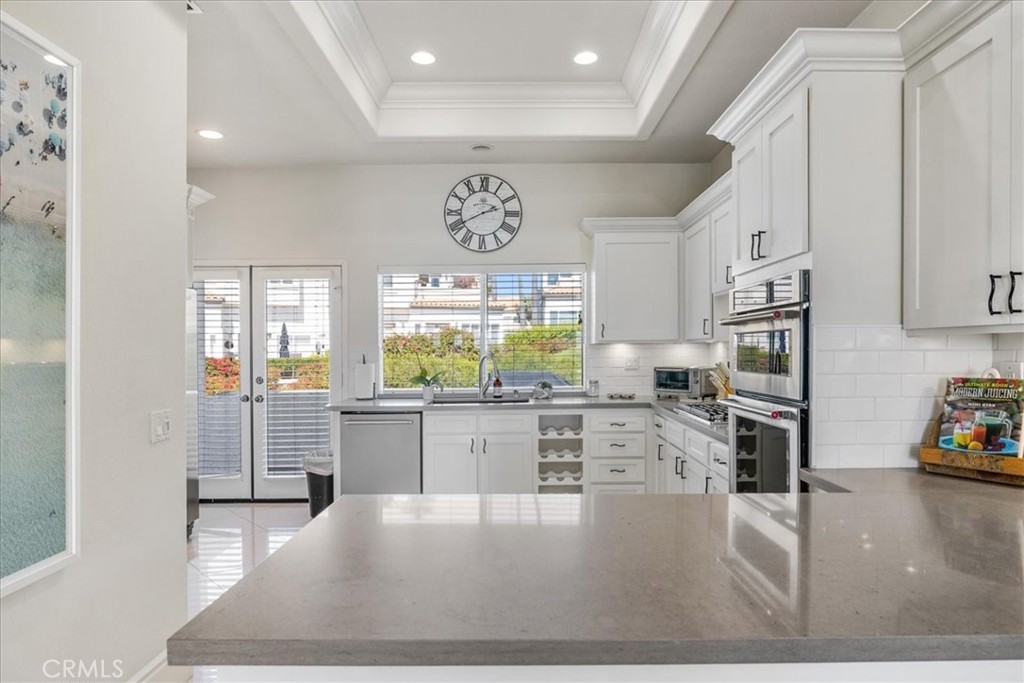 17 Centre Court Dana Point, CA 92629 - Photo 12 of 45 a kitchen with stainless steel appliances granite countertop a stove top oven a sink a dining table and chairs with wooden floor