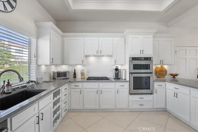 a kitchen with granite countertop white cabinets and white appliances