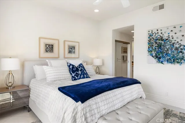 a large bedroom with a bed and a lamp with wall painting