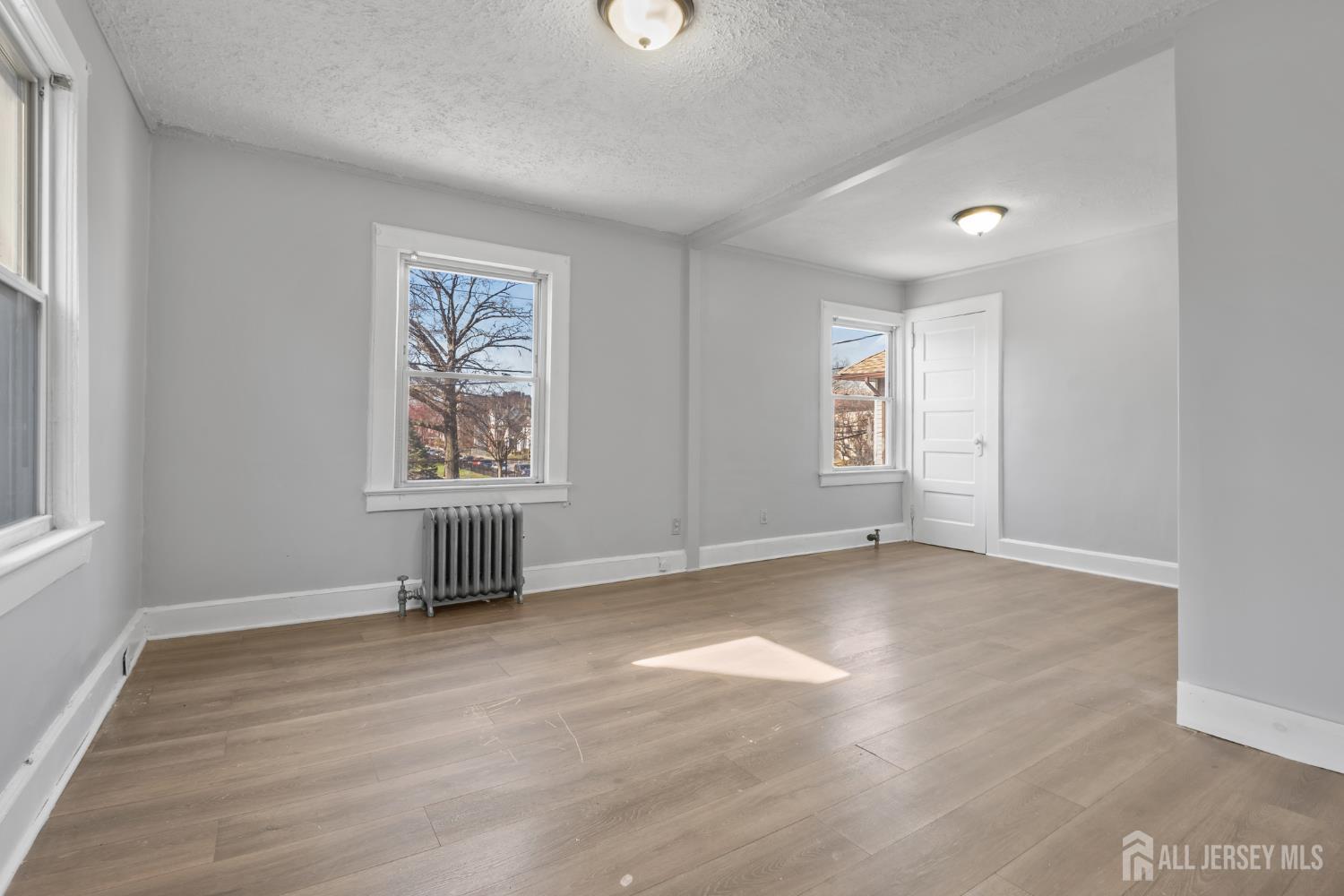 83 May Street Irvington, NJ 07111 - Photo 17 of 27 an empty room with windows and fan