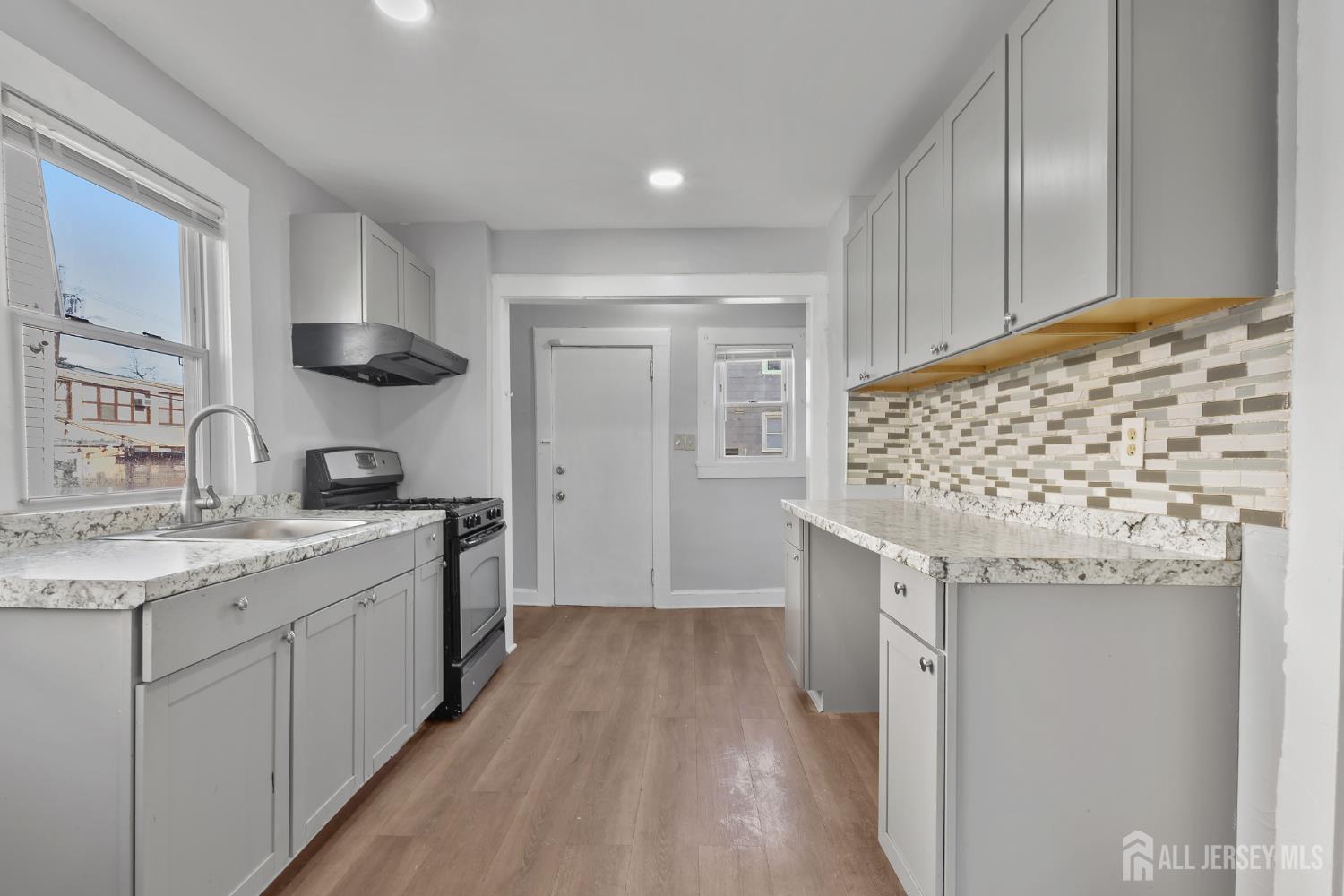 83 May Street Irvington, NJ 07111 - Photo 2 of 27 a kitchen with granite countertop a sink and cabinets
