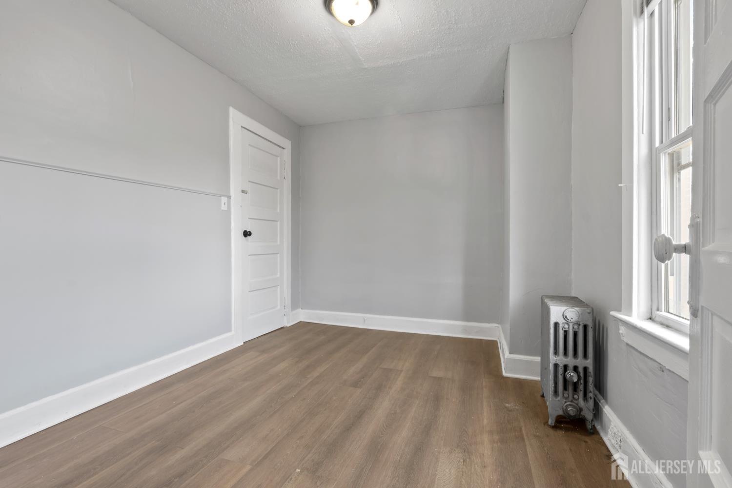 83 May Street Irvington, NJ 07111 - Photo 21 of 27 a view of room with window and wooden floor