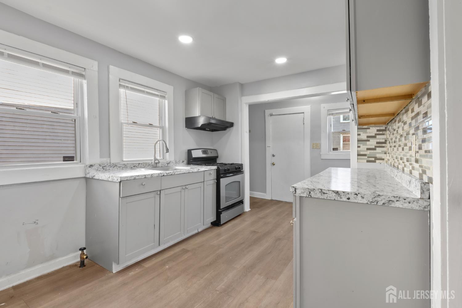 83 May Street Irvington, NJ 07111 - Photo 4 of 27 a kitchen with a sink stove and cabinets
