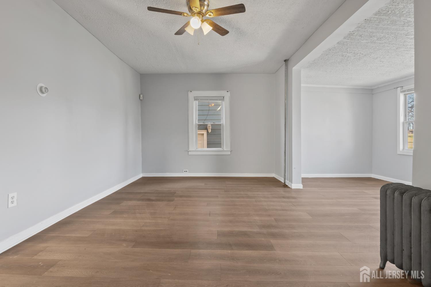 83 May Street Irvington, NJ 07111 - Photo 5 of 27 a view of an empty room with wooden floor and a window