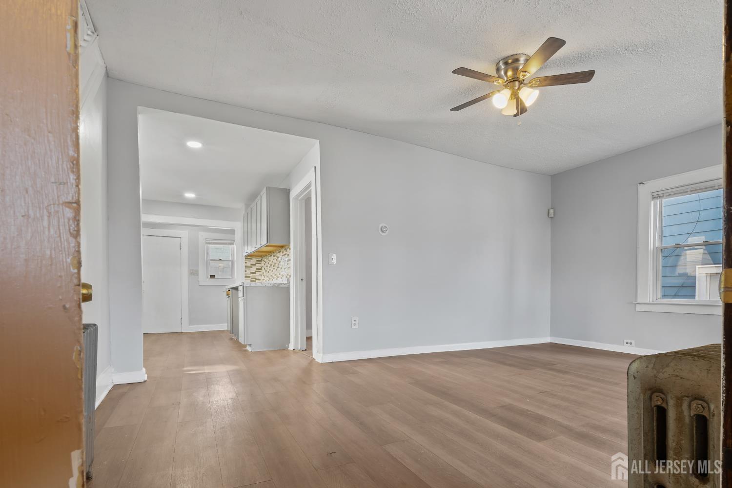 83 May Street Irvington, NJ 07111 - Photo 8 of 27 a view of a livingroom with a chandelier fan and wooden floor