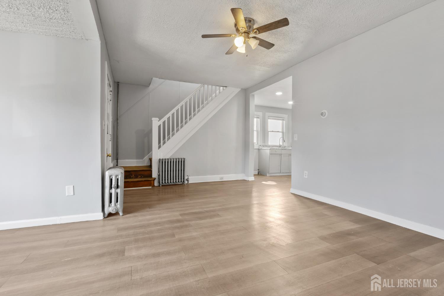 83 May Street Irvington, NJ 07111 - Photo 9 of 27 wooden floor in an empty room with a window