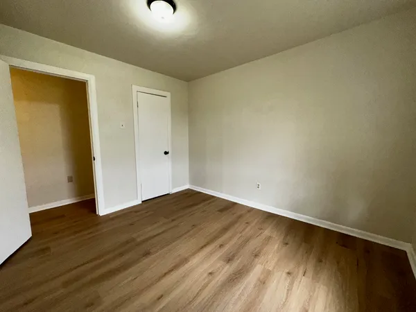 a view of an empty room with wooden floor
