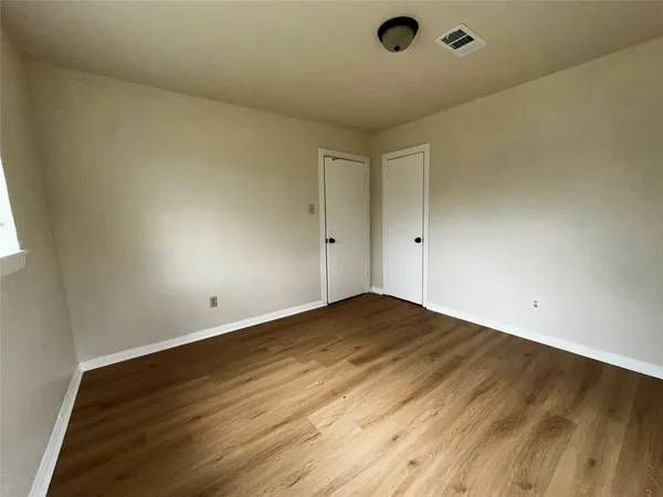 a view of an empty room and wooden floor