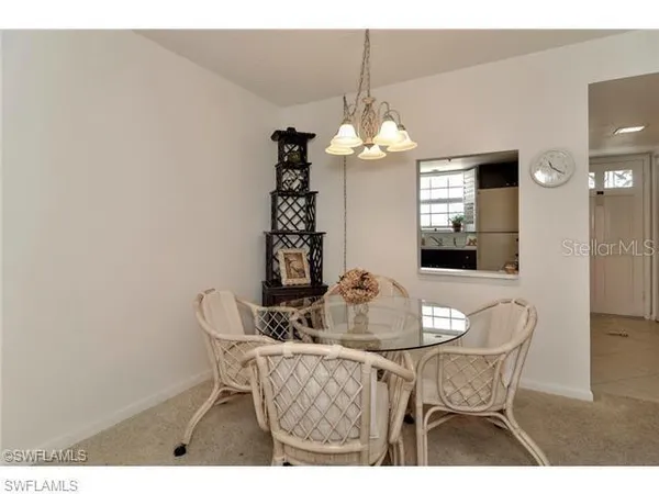 a dining room with furniture a chandelier and window