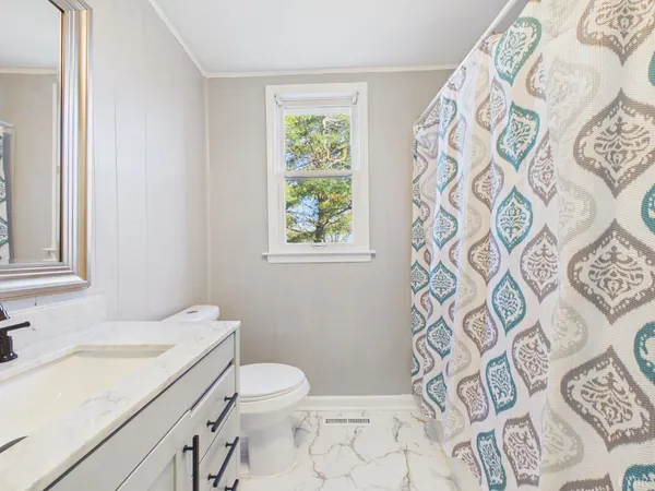 a bathroom with a granite countertop toilet sink and mirror