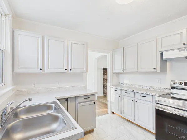 a kitchen with granite countertop white cabinets and stainless steel appliances