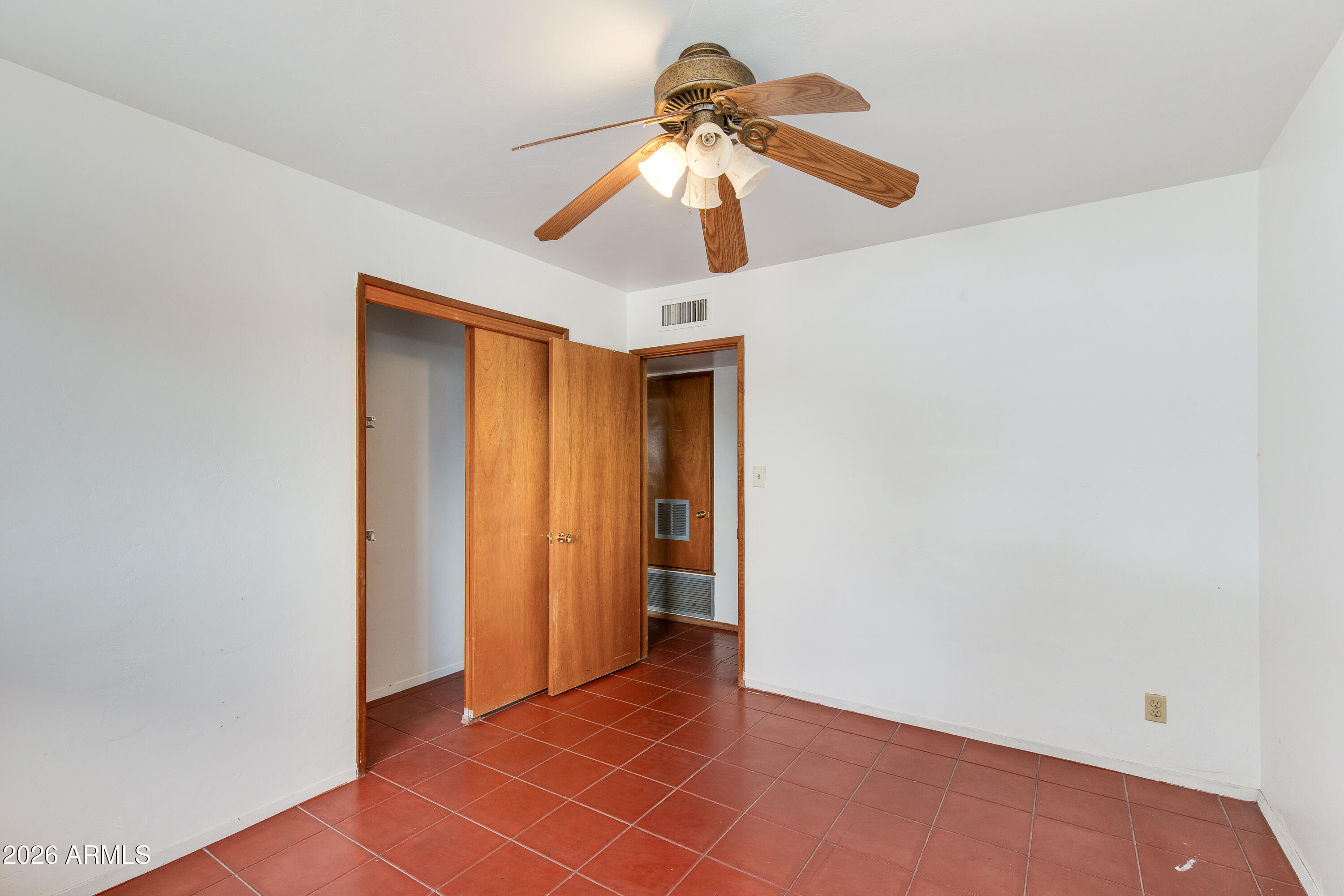 1524 West Ocotillo Road Phoenix, AZ 85015 - Photo 21 of 29 an empty room with closet and a chandelier fan