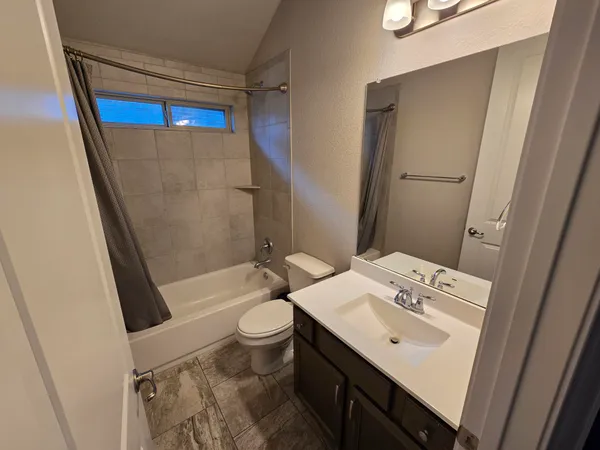 a bathroom with a sink a toilet a mirror and shower