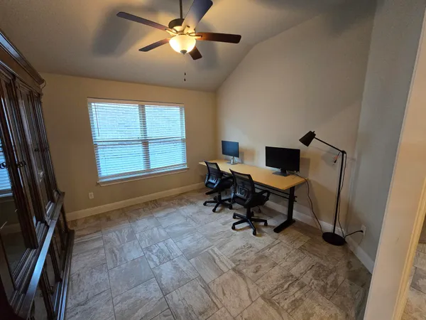 a view of a workspace with furniture and a window