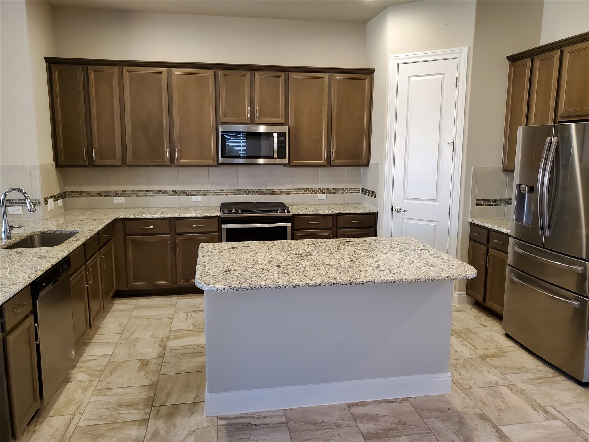 539 Tanda Lane Hutto, TX 78634 - Photo 6 of 18 a kitchen with stainless steel appliances granite countertop a stove a refrigerator and a sink