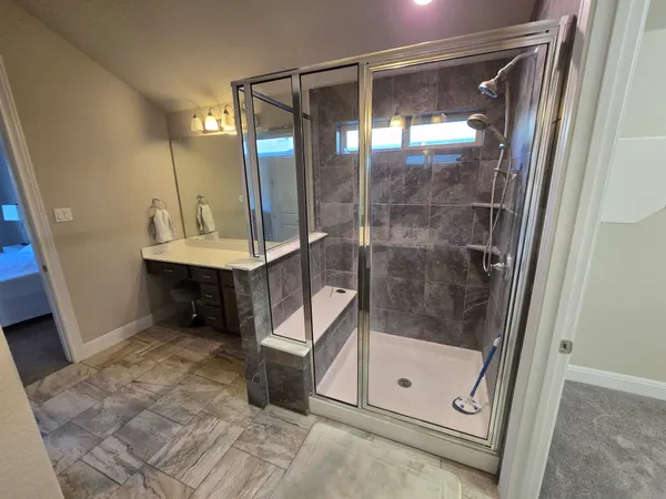 a bathroom with a glass shower door and a sink