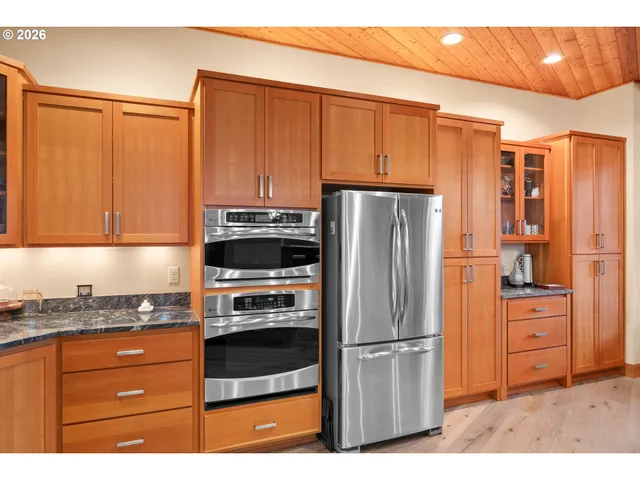 a kitchen with stainless steel appliances granite countertop a refrigerator stove and cabinets