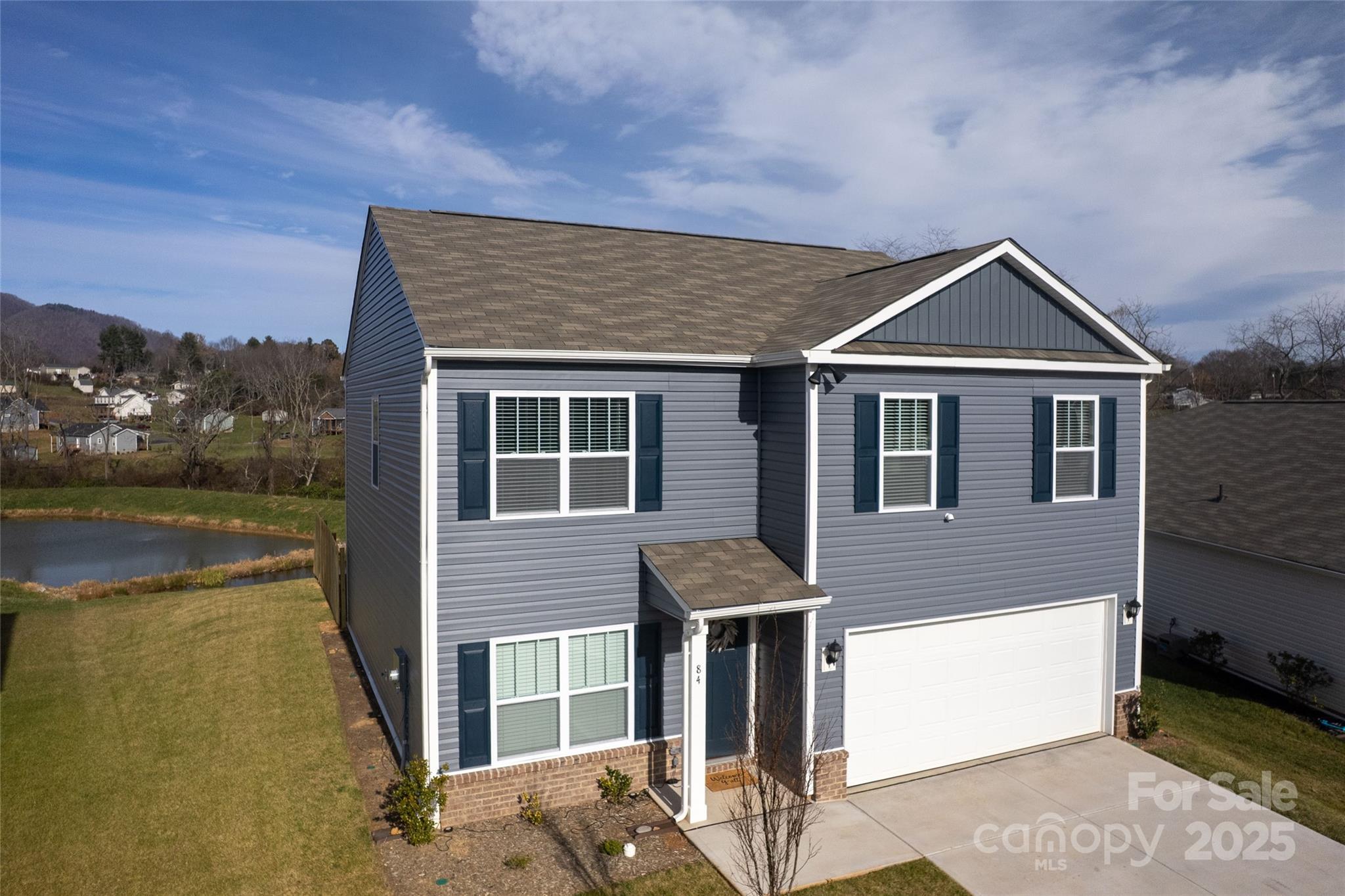 84 Madelyn Drive Clyde, NC 28721 - Photo 22 of 29 a front view of a house with a yard and lake view