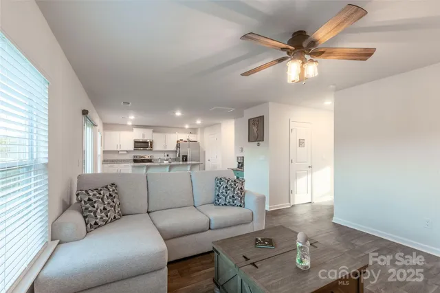 a living room with furniture and kitchen view