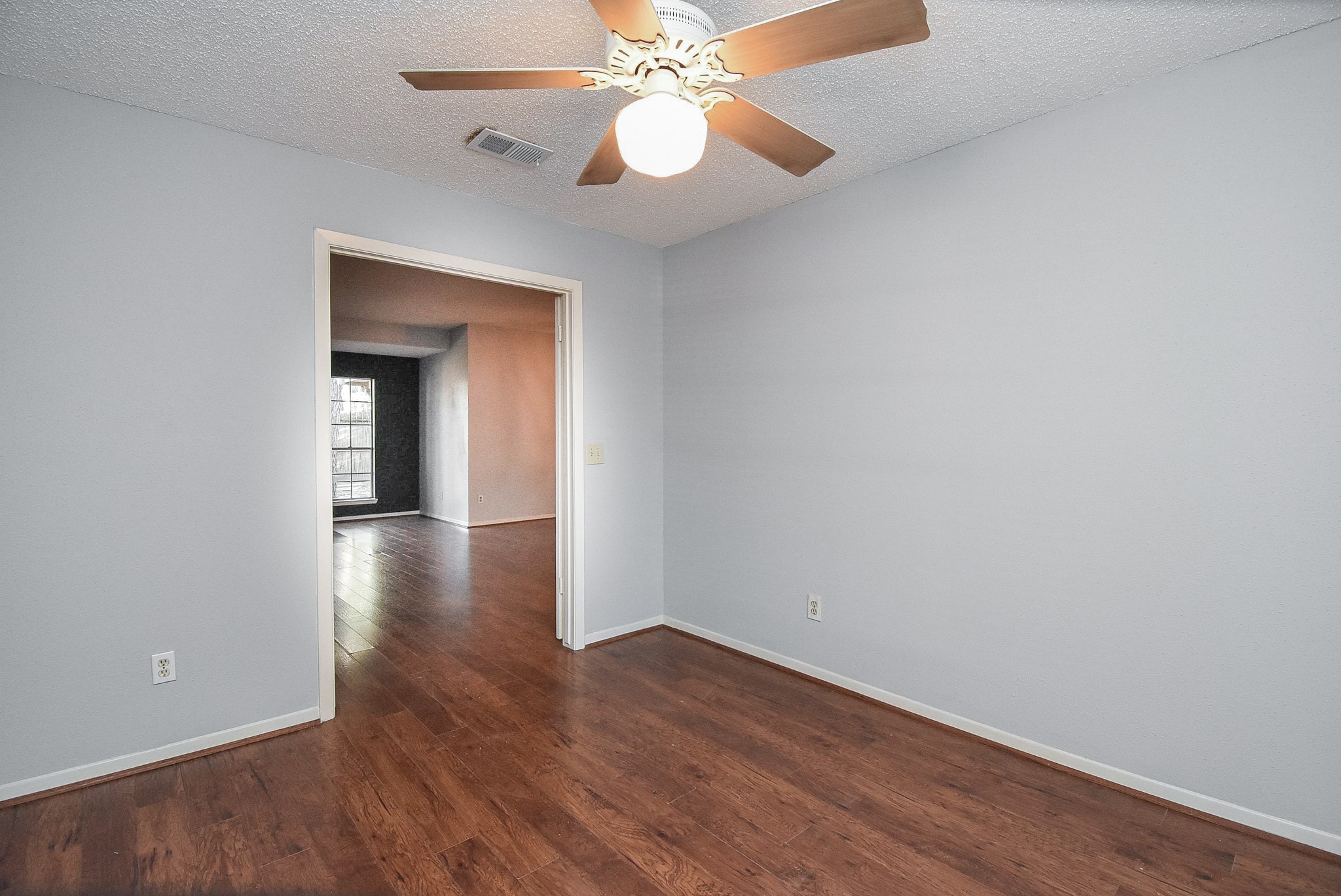 9107 Wallingham Court Spring, TX 77379 - Photo 22 of 25 a view of an empty room with wooden floor and a ceiling fan