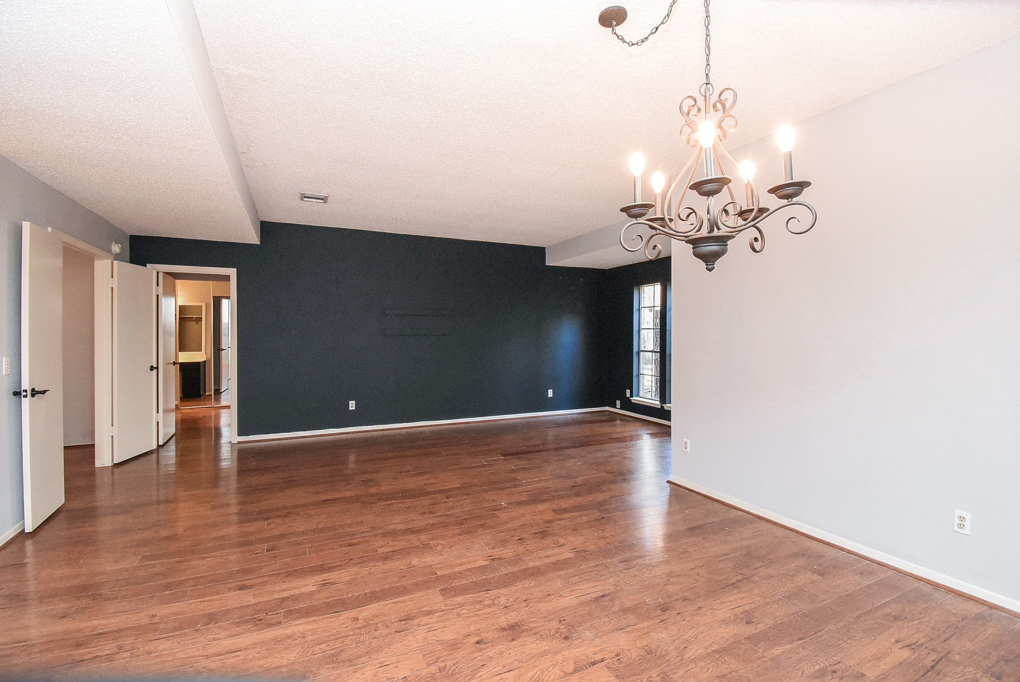 9107 Wallingham Court Spring, TX 77379 - Photo 3 of 25 a view of an empty room with wooden floor and a chandelier