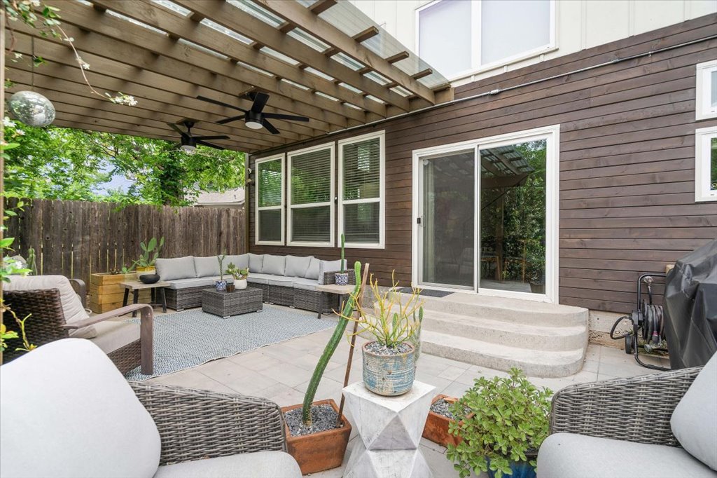 1800 Webberville Road, Unit B Austin, TX 78721 - Photo 28 of 30 Covered patio featuring a slatted wood pergola, two ceiling fans, and a sliding glass door
