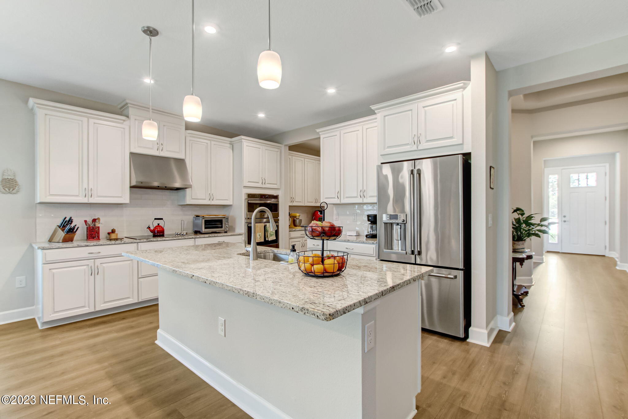 85276 Berryessa Way Yulee, FL 32097 - Photo 16 of 42 a kitchen with a refrigerator a stove and wooden floor